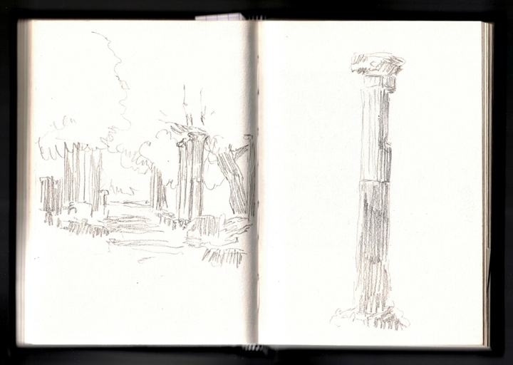 On the left, a passage way lined with trees and columns, creating a shadowy space underneath. On the right, a single marble column with a sculpted top and stripes along its body.
